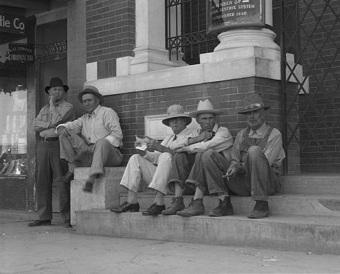 The “Spit and Whittle” club meets on the steps of the bank in Memphis.