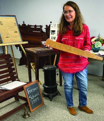 Collingsworth County Museum Director Karen Caldwell demonstrates items, such as a long paddle, in the collection of artifacts from the many county schools. Collingsworth County Retired School Personnel met at the museum for its March meeting. Courtesy Photo